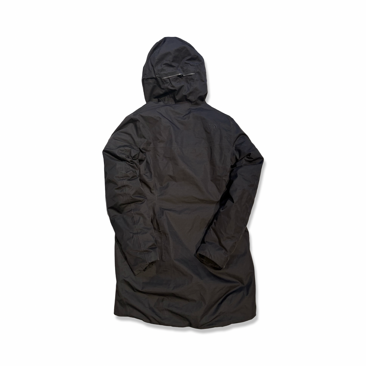 Baksidan av en svart parkas från The North Face för dam med huva, fotograferad mot en vit bakgrund.