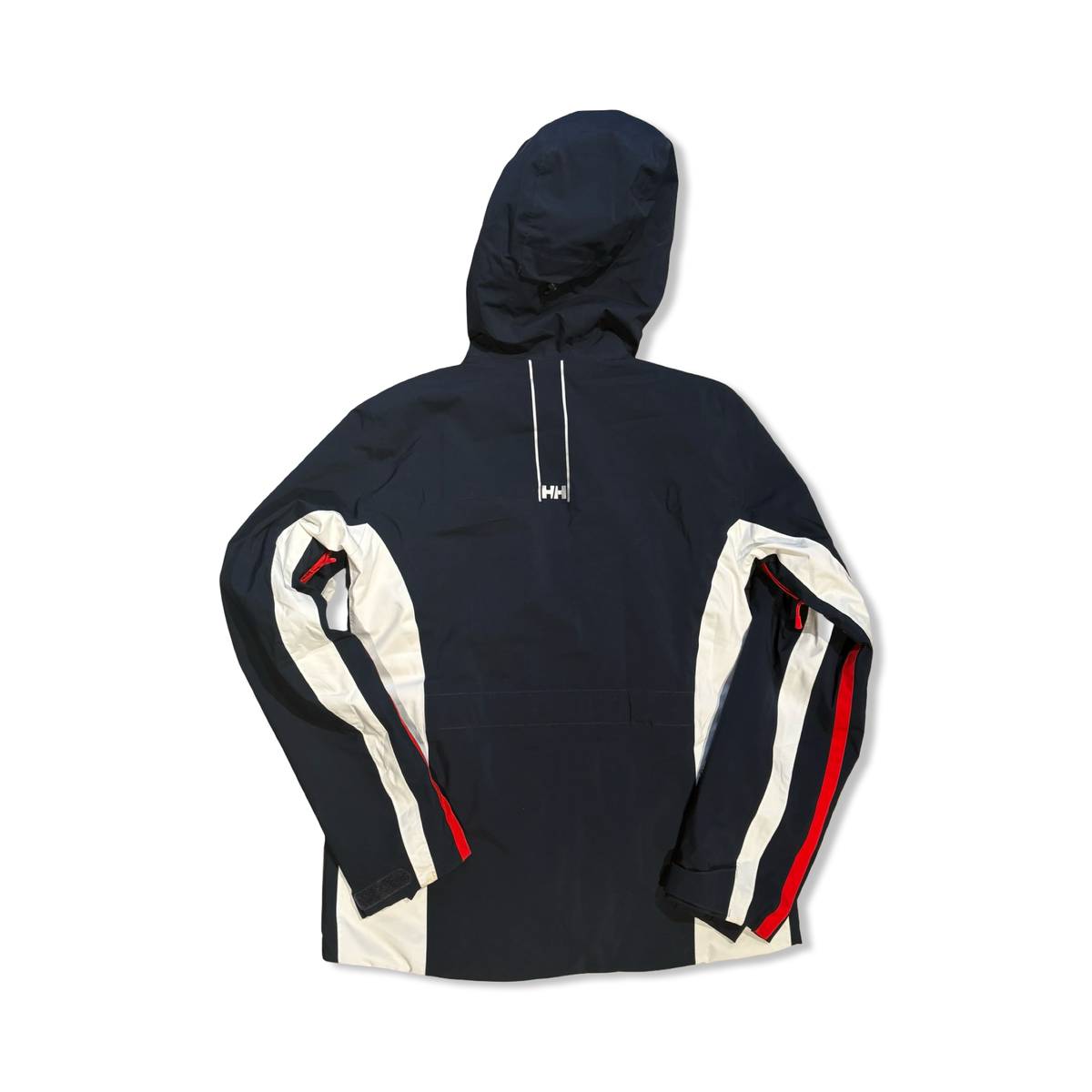 Baksidan av en mörkblå och vit skidjacka från Helly Hansen för dam med huva, fotograferad mot en vit bakgrund.
