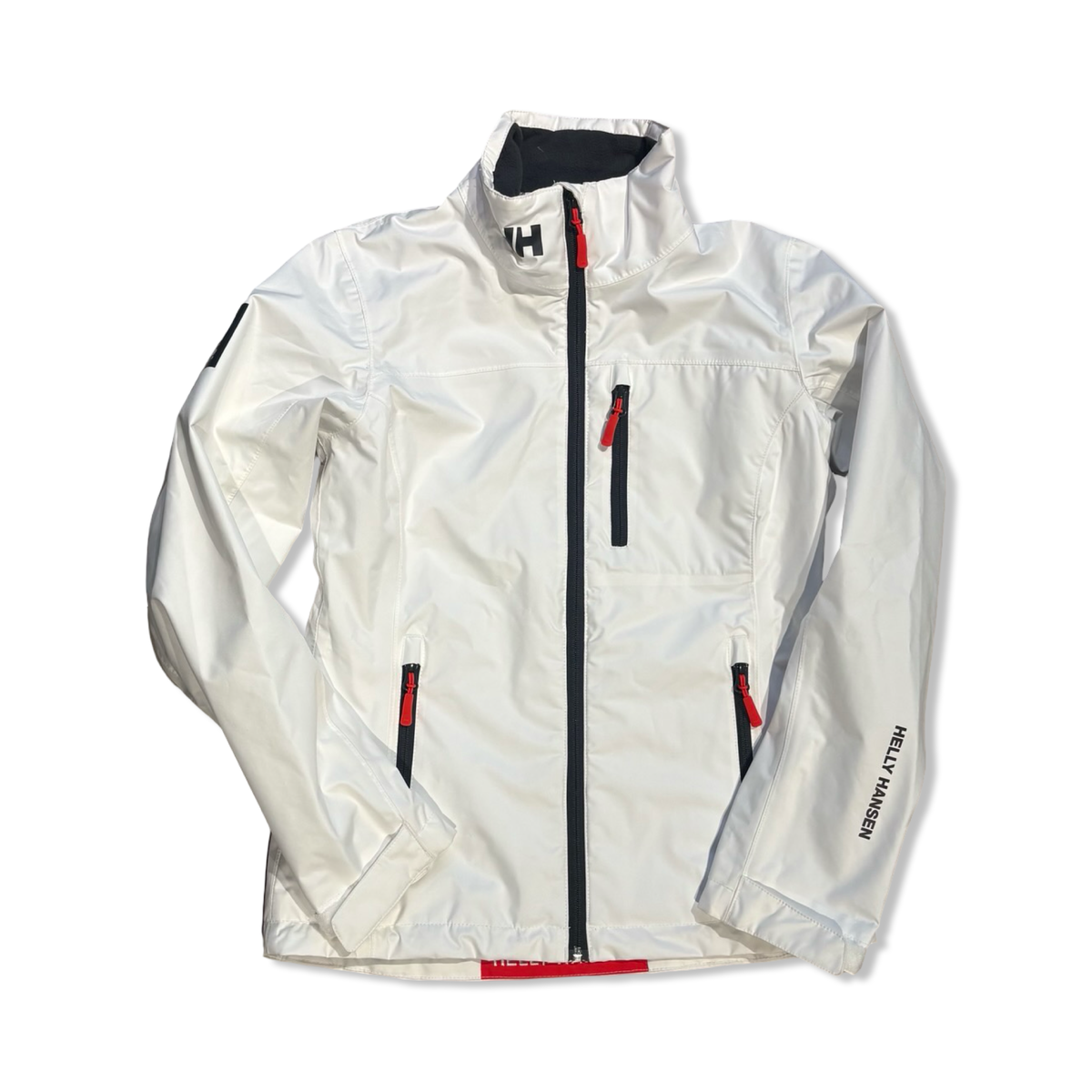 Vit damjacka Helly Hansen Crew Sailing Jacket 2.0 i modell med dragkedja, fotograferad framifrån mot en vit bakgrund.