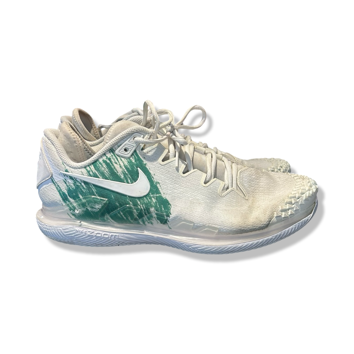 Vita och gröna träningsskor Nike NikeCourt Air Zoom Vapor X Knit för herr, fotograferade från sidan mot en vit bakgrund.