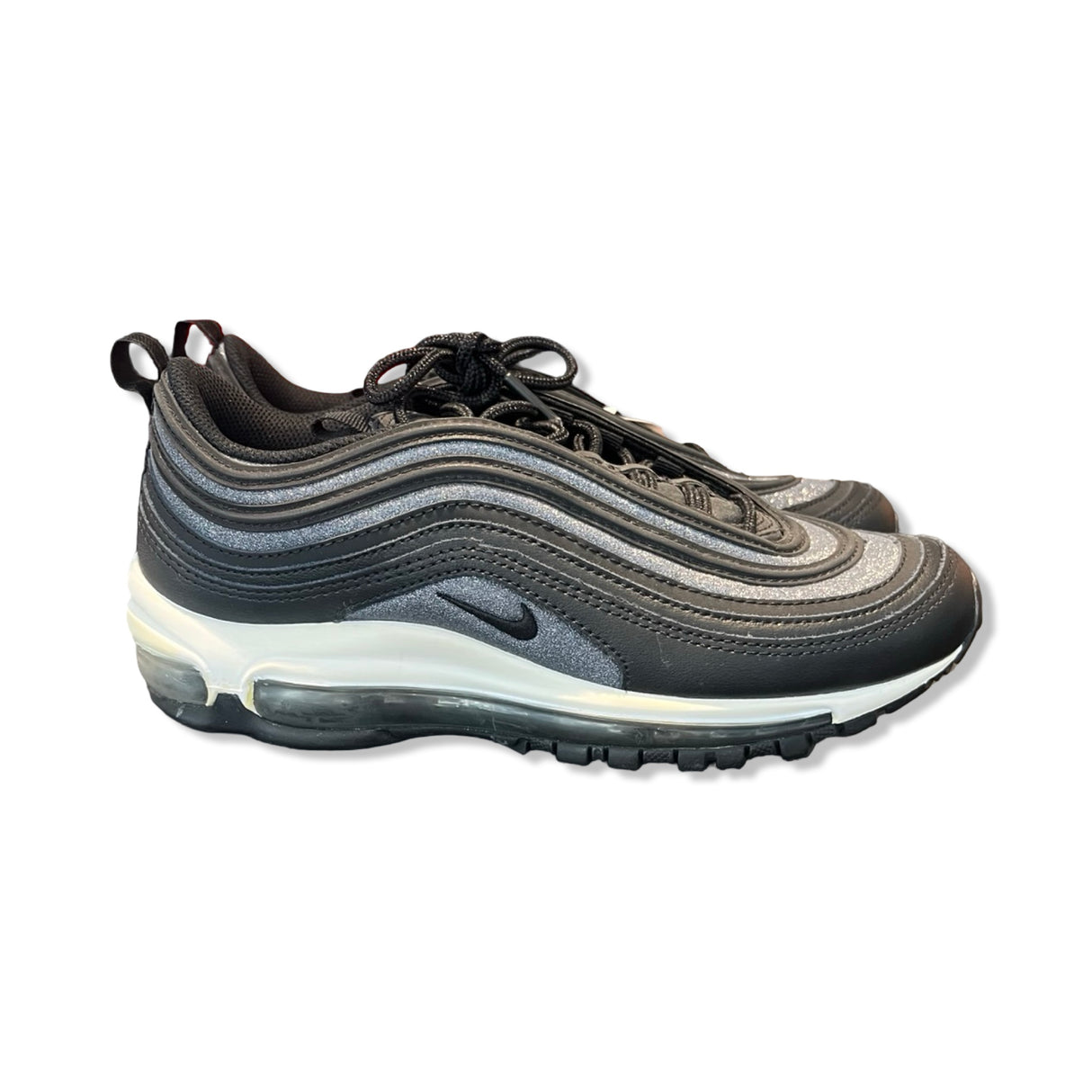 Nike Air Max 97 sneakers för dam i svart och silver med glitter, fotograferade från sidan mot en vit bakgrund.