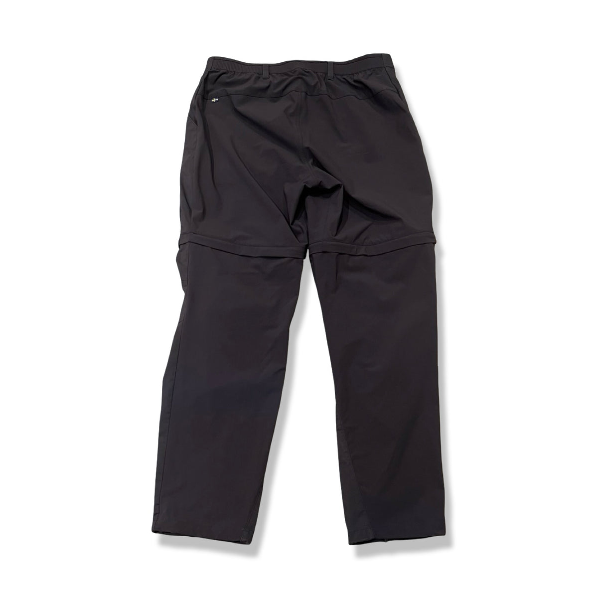 Baksidan av ett par mörkblå Fjällräven Abisko Hybrid Trail Trousers för dam, fotograferade mot en vit bakgrund.