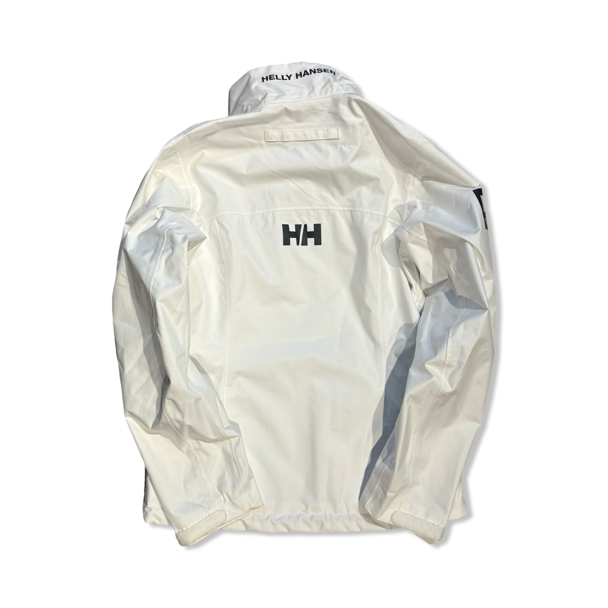 Baksidan av en vit Helly Hansen Crew Sailing Jacket 2.0 skaljacka för dam, fotograferad mot vit bakgrund.