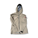 Beige skaljacka Peak Performance W Alpine Gore-Tex jacket med huva, fotograferad framifrån mot en vit bakgrund.