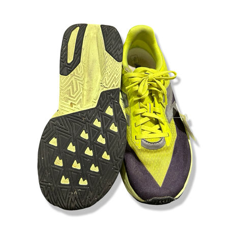 Ett par gula New Balance FuelCell Rebel löparskor för herr, visade med en sula och en ovansida mot vit bakgrund.