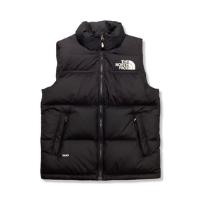 Svart väst från The North Face Teen 1996 Retro Nuptse för barn, fotograferad framifrån mot en vit bakgrund.