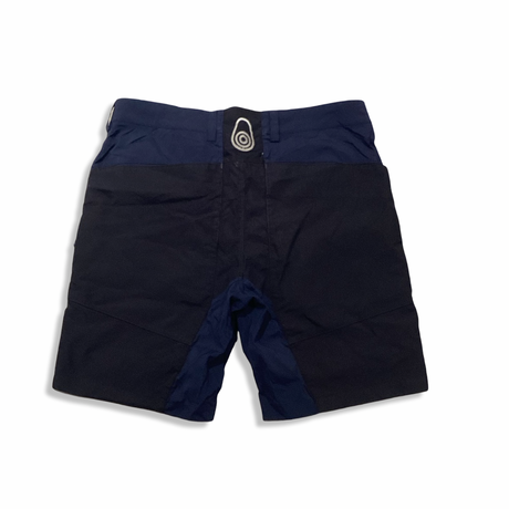 Baksidan av blå seglarshorts för herr från Sail Racing, fotograferade mot en vit bakgrund.