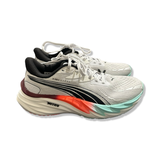 Vita löparskor Puma Velocity Nitro 4 HYDROX för dam med svarta detaljer, fotograferade från sidan mot en vit bakgrund.
