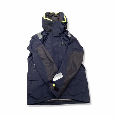 Blå seglarjacka från Helly Hansen för dam med luva, fotograferad framifrån mot en vit bakgrund.
