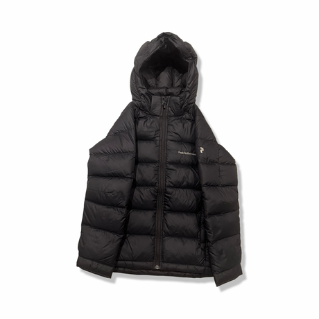 Svart dunjacka från Peak Performance JR Frost down jacket för dam, fotograferad framifrån mot en vit bakgrund.