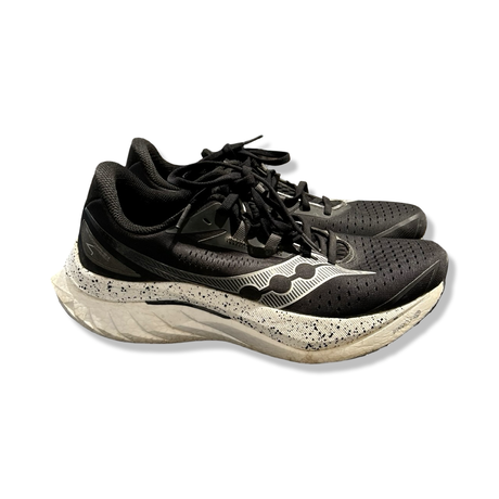 Svart par löparskor Saucony Endorphin Speed 4 för dam, fotograferade från sidan mot en vit bakgrund.