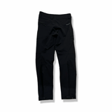 Baksidan av ett par svarta Norröna svalbard flex pants för dam, fotograferade mot en vit bakgrund.