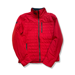 Röd syntetjacka från Helly Hansen för dam med dragkedja och bröstficka, fotograferad framifrån mot en vit bakgrund.