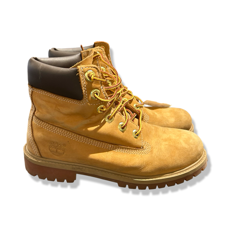 Ett par bruna kängor från Timberland för dam i storlek 38, fotograferade från sidan mot en vit bakgrund.