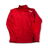 Baksidan av en röd softshelljacka från Helly Hansen för dam med vit logotyp, fotograferad mot en vit bakgrund.