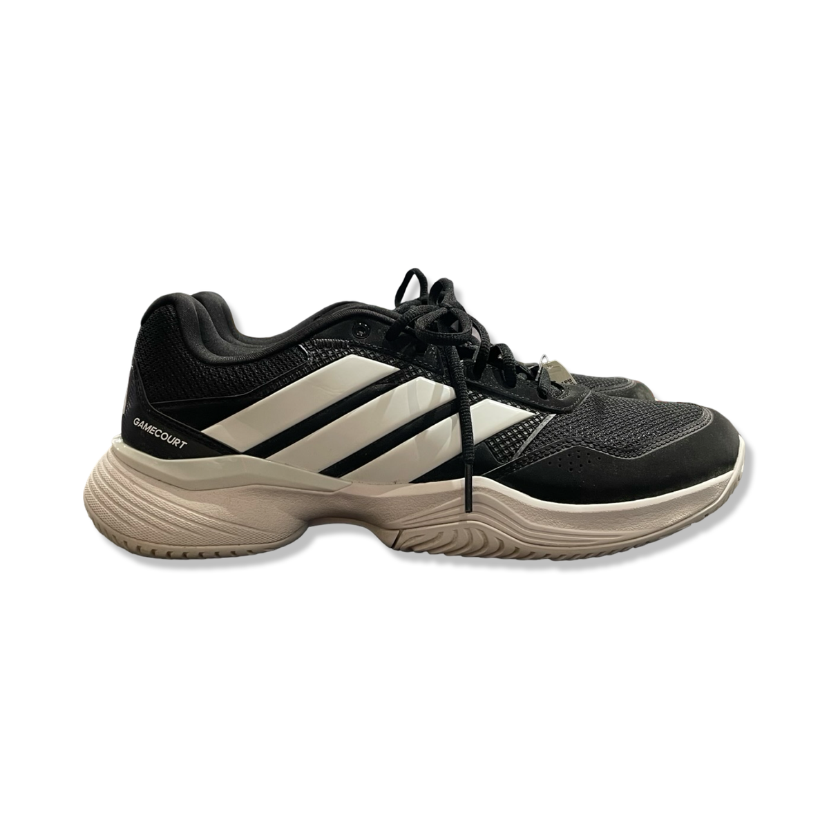 Ett par svarta och vita löparskor från Adidas, modell Gamecourt för herr, fotograferade från sidan mot en vit bakgrund.