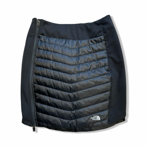 Svart Primaloftkjol från The North Face för dam med dragkedja i sidan, fotograferad framifrån mot en vit bakgrund.