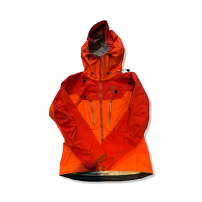 Orange Arc'teryx Alpha AR skaljacka för dam i Gore-Tex Pro, fotograferad framifrån mot en vit bakgrund.
