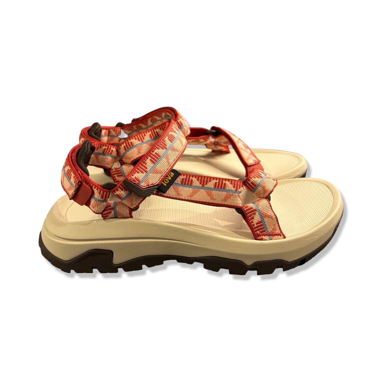 Teva Hurricane XL T3 sandaler för dam i beige och rött mönster, fotograferade från sidan mot vit bakgrund.