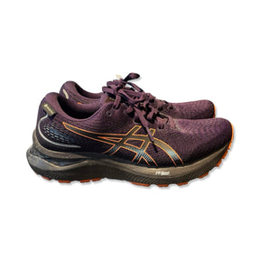 Lila Asics Gel-Cumulus 24 GTX löparskor för dam med orange detaljer, sedda från sidan mot vit bakgrund.