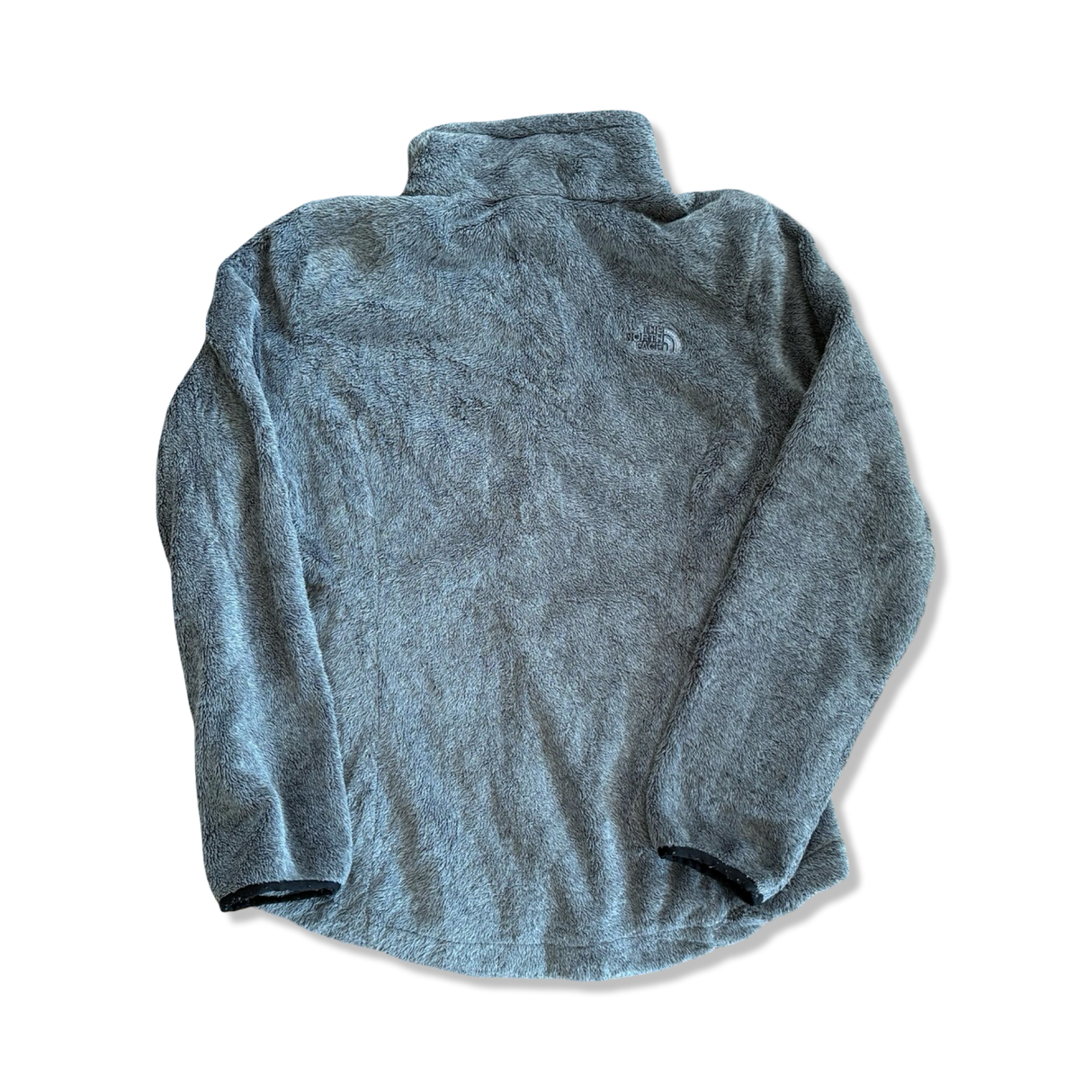 Grå fleecetröja för dam från The North Face i mjukt, lurvigt material, sedd bakifrån mot vit bakgrund.
