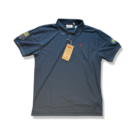 Mörkblå Fjällräven Crowley Pique-shirt för herr, fotograferad platt framifrån mot en vit bakgrund.