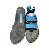 Svart och blå klätterskor för dam från Scarpa Origin med kardborreband, visade med undersidan och ovansidan mot en vit bakgrund.