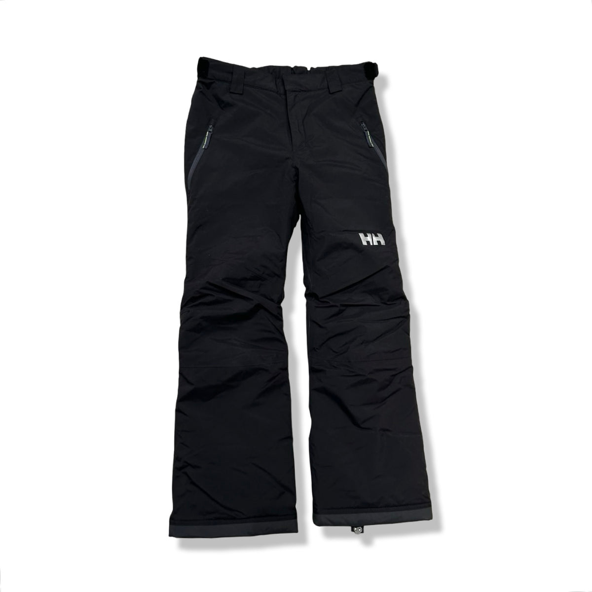 Svarta skidbyxor för barn från Helly Hansen med dragkedjefickor, fotograferade framifrån mot en vit bakgrund.
