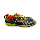 Svart träningsskor från Merrell med gula detaljer, fotograferad från sidan mot en vit bakgrund.