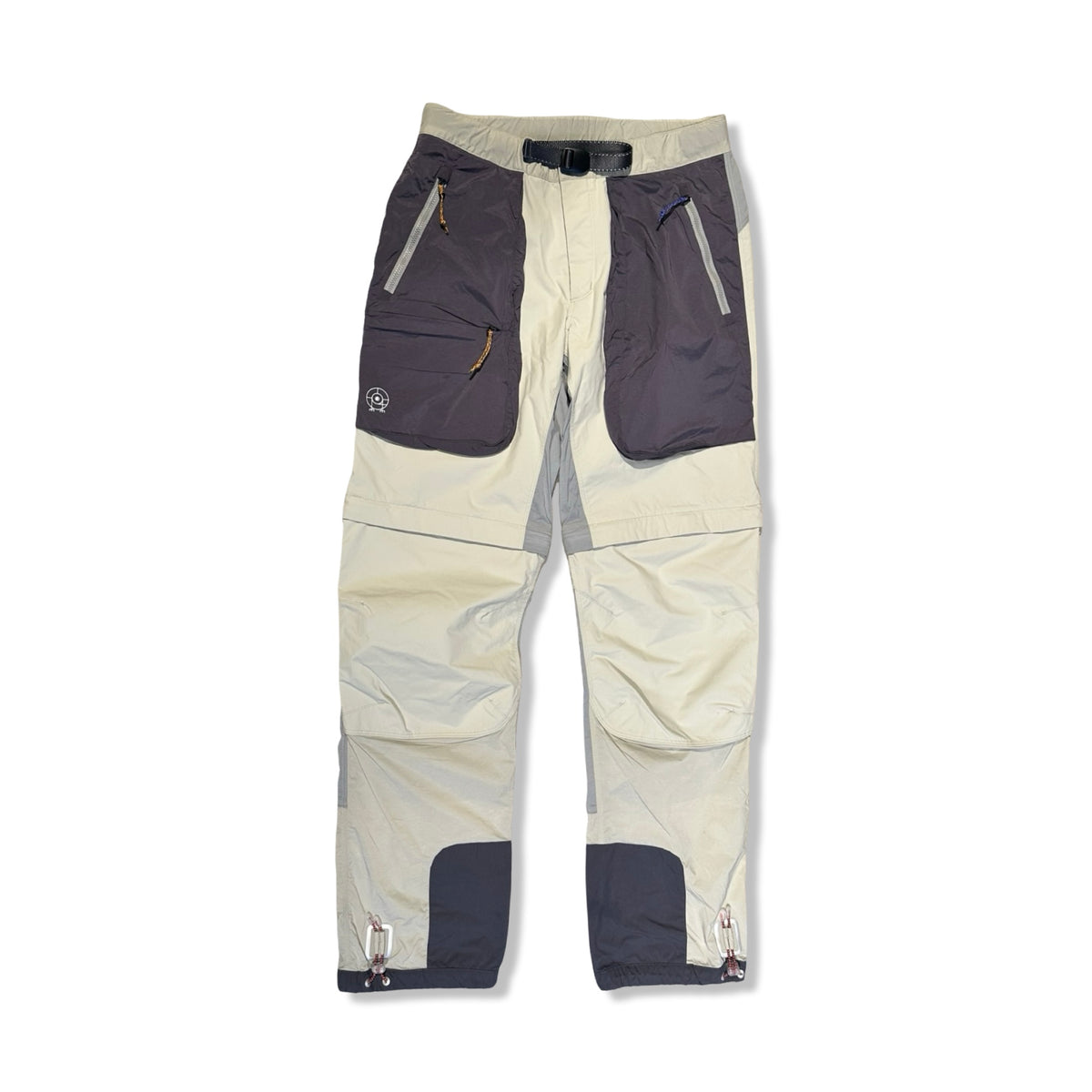 Beige funktionsbyxor från Peak Performance för dam med mörka fickdetaljer, fotograferade framifrån mot en ljus bakgrund.