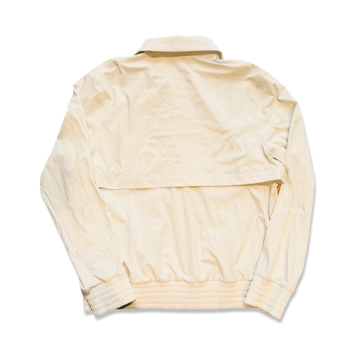Off-white Lululemon träningsjacka sedd bakifrån med ventilationsöppning på ryggen mot en vit bakgrund.