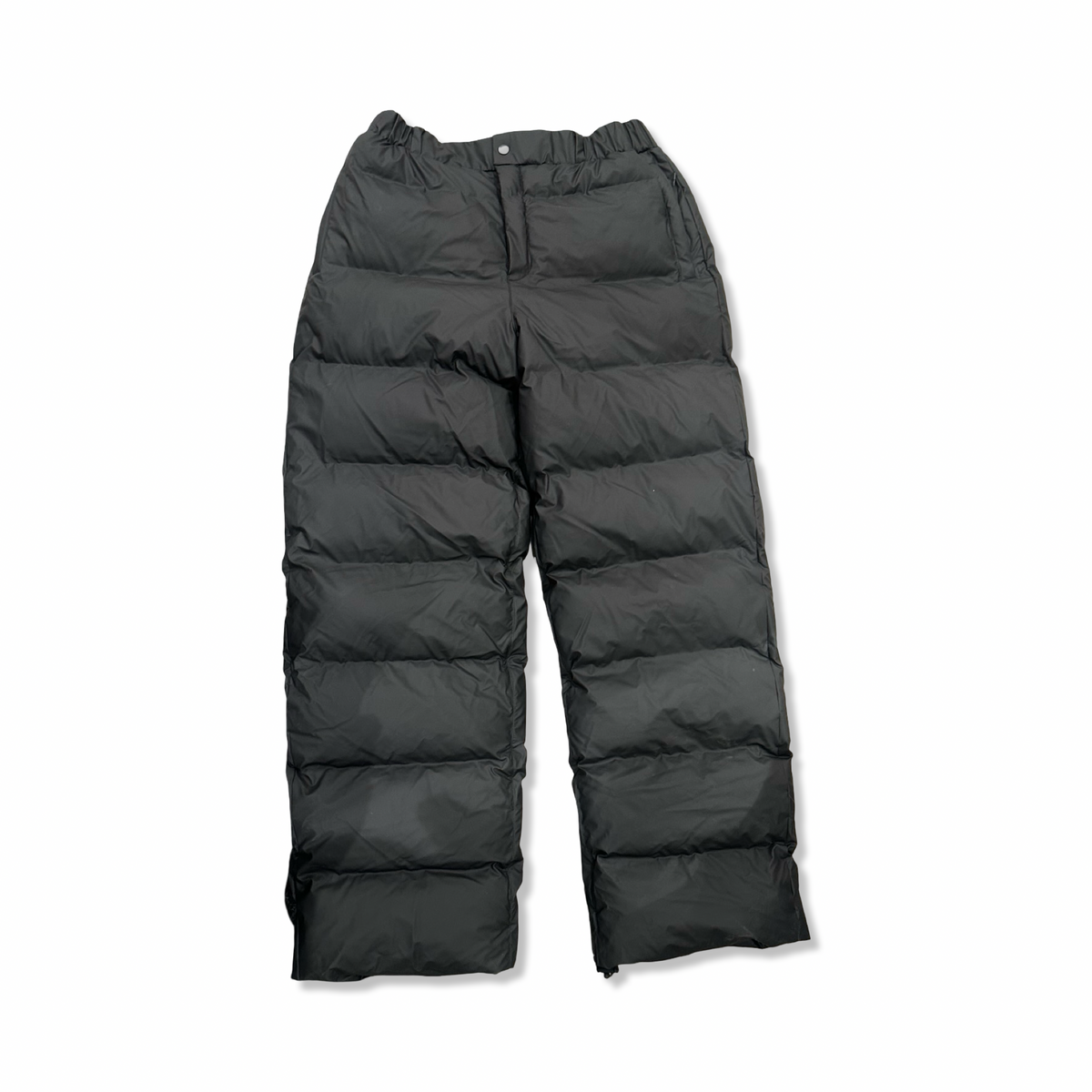 Svara puffbyxor från Rains för dam i modell Alta puffer pants, fotograferade framifrån mot en vit bakgrund.
