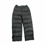 Svara puffbyxor från Rains för dam i modell Alta puffer pants, fotograferade framifrån mot en vit bakgrund.