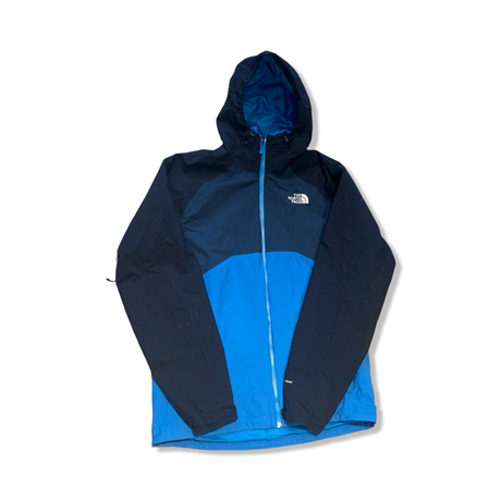 Blå tvåfärgad skaljacka från The North Face för herr, fotograferad framifrån mot en vit bakgrund.