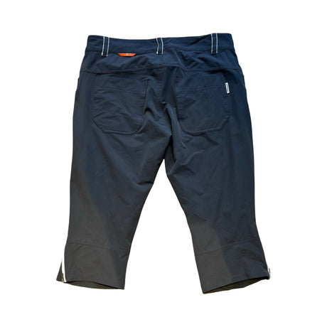 Svarta Peak Performance Agile caprishorts för dam med bakfickor, fotograferade bakifrån mot en vit bakgrund.