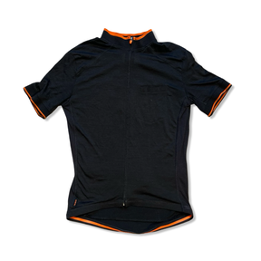 Triban svart kortärmad cykeltröja för dam med orangea detaljer och dragkedja, sedd framifrån mot en vit bakgrund.