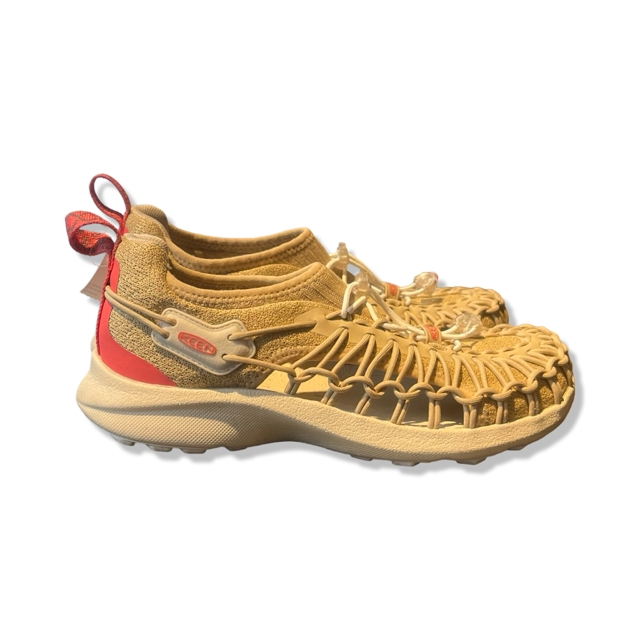 Beige Keen-sandaler för dam med röd häl och flätad design, fotograferade från sidan mot en vit bakgrund.